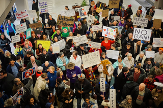Hundreds of protesters fill the allotted area of the Syracuse airport. Signs range from expressing anti-Trump sentiments to showing solidarity with Muslims.