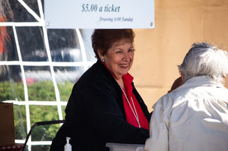 Festival founder Ginnie Lostumbo laughs with festival-goers while selling raffle tickets. Lostumbo said the people, attendees and volunteers are her favorite part of Festa Italiana.